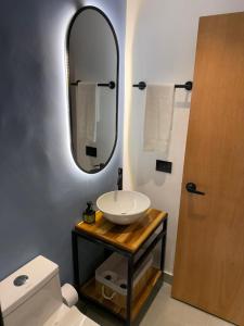 un baño con lavabo y espejo en Living Sincelejo, en Sincelejo