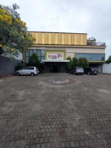 a building with cars parked in a parking lot at Dgria Family Hotel by TripleTree in Banjar