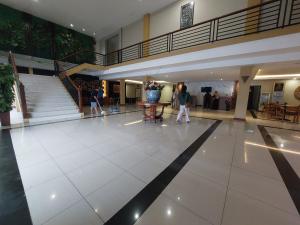 a lobby with people walking in a building at Dgria Family Hotel by TripleTree in Banjar
