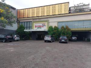 a parking lot with cars parked in front of a building at Dgria Family Hotel by TripleTree in Banjar +4 photos