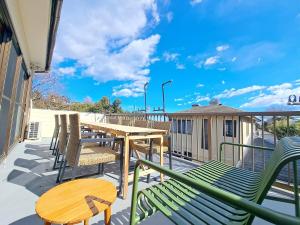 a balcony with chairs and a wooden table and a table at 西逸見 in Yokosuka