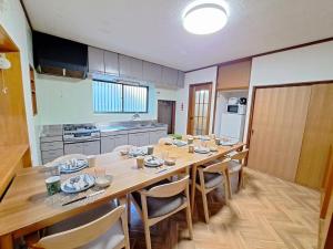 a kitchen with a long wooden table and chairs at 西逸見 in Yokosuka