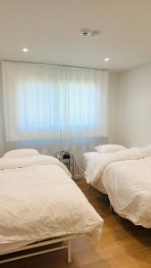 a bedroom with two beds and a window at 함덕우리집 in Hamdŏng-ni