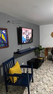 a living room with a blue chair and a tv at Apartamento thecanarys in Santa Rosa de Cabal