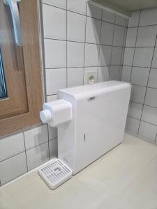 a white toilet in a bathroom next to a mirror at 함덕우리집 in Hamdŏng-ni +24 photos