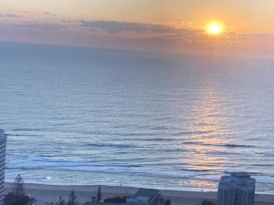a view of the ocean at sunset from a building at Beach front apartment in Batemans Bay