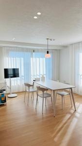 a dining room with a table and chairs and a television at 함덕우리집 in Hamdŏng-ni