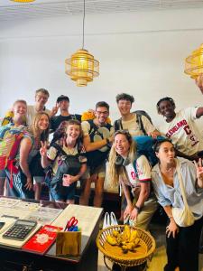 a group of people posing for a picture in a room at Sanga Rooftop Hostel in Pakse