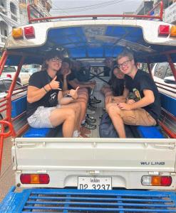 a group of people sitting in the back of a truck at Sanga Rooftop Hostel in Pakse