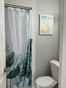 bagno con tenda doccia e servizi igienici di Surrey Home - King George Blvd & Rapid Transit - Airport 25 Min - Free Parking & Wi-Fi a Surrey