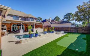 een huis met een tuin met een zwembad en gras bij Heated Pool • Hot Tub • Game Loft • 4BR in Atascocita