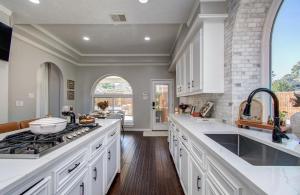 een keuken met witte kasten en een kookplaat oven bij Heated Pool • Hot Tub • Game Loft • 4BR in Atascocita