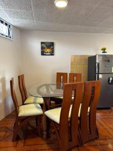 キトにあるDepa Guajaló - Quicentro Sur con Terraza y Parkingのダイニングルーム(テーブル、椅子、冷蔵庫付)