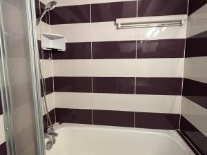 a bathroom with a black and white tiled wall at Charmant T3 au cœur du village pour 5 personnes - FR-1-761-31 in Villard-de-Lans