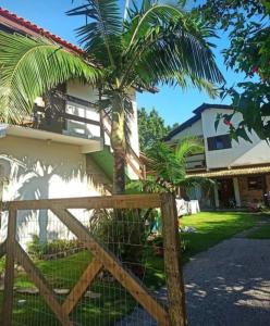 a palm tree in front of a house at Moradas Cantinho da Guarda in Guarda do Embaú