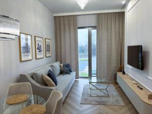 ein Wohnzimmer mit Sofa und Fernseher in der Unterkunft Apartament Heaven Hampton in Olsztyn