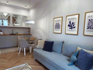 ein Wohnzimmer mit einer blauen Couch und einer Küche in der Unterkunft Apartament Heaven Hampton in Olsztyn