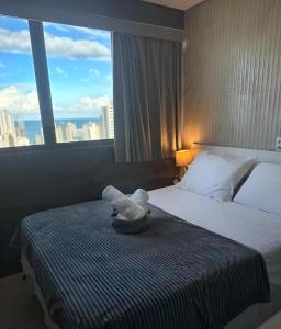 um quarto de hotel com uma cama com uma janela grande em Flat 26º andar com vista para o mar- Próximo ao shopping e à praia de Boa Viagem em Recife