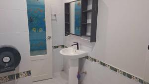 een witte badkamer met een wastafel en een spiegel bij Sukkeehouse in Ko Larn +10 foto's