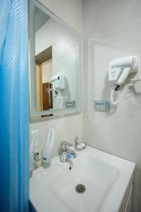 a bathroom with a white sink and a mirror at Floranta Hotel in Qarshi