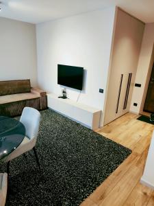 a living room with a flat screen tv on a white cabinet at Apartamentai šalia miesto centro in Telšiai