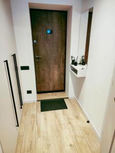 a hallway with a brown door and a wooden floor at Apartamentai šalia miesto centro in Telšiai