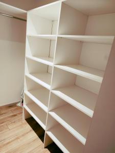 a white book shelf in a room at Apartamentai šalia miesto centro in Telšiai +3 photos