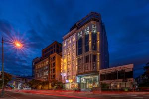 Tago Airport Hotel في مدينة هوشي منه: مبنى شاهق في أحد شوارع المدينة ليلاً