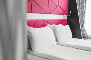 a bed with two white pillows and a pink headboard at Prize by Radisson, Xhibition Bergen City in Bergen +60 photos
