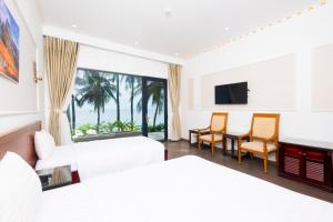 a hotel room with a bed and a table and chairs at Hawaii Resort Phu Quoc in Phu Quoc