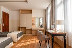 Tago Airport Hotel في مدينة هوشي منه: غرفة نوم مع مكتب وسرير ومكتب sidx sidx