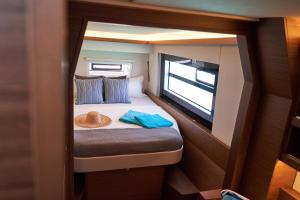 ein kleines Schlafzimmer mit einem Bett, auf dem ein Hut liegt in der Unterkunft Catamaran Liveaboard Charters Mauritius in Rivière Noire