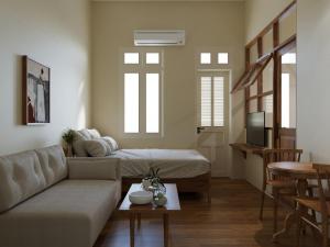 a living room with a couch and a bed at Indochine Gloria Home by Silk Path in Hanoi