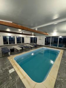 una grande piscina in un edificio con tavoli e sedie di Cabana Erta a Tireu