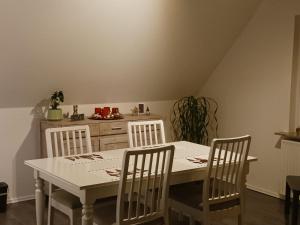 a kitchen with a white table and four chairs at Seeblick- Noer in Noer
