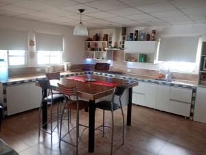 eine Küche mit einem Holztisch und einigen Stühlen in der Unterkunft La Soñada in Villa Parque Siquiman