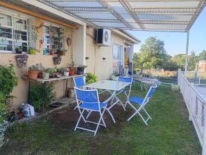eine Terrasse mit einem Tisch und Stühlen auf dem Rasen in der Unterkunft La Soñada in Villa Parque Siquiman