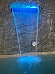 a waterfall in a pool of water with blue lights at Casa Emma fantástica con acceso a beach club ! in Holbox Island +29 photos