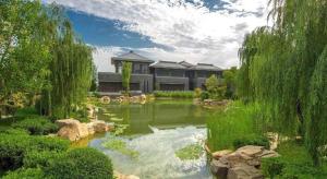 a garden with a pond in front of a building at Xian Elegant Oriental Hotel in Xi'an