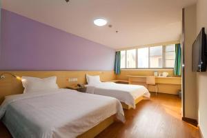 a hotel room with two beds and a television at 7 Days Inn Chengdu North Railway Metro Station in Chengdu +198 photos