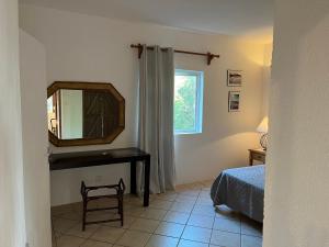 a bedroom with a mirror and a bed and a window at Tropical Studio in Tamarin