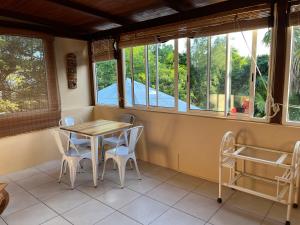 a room with a table and chairs and windows at Tropical Studio in Tamarin