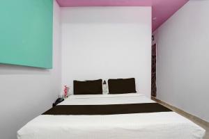 a bedroom with a white bed with black pillows at Collection ORudrapurBus StandFormerly Corinthian in Rāmpura +23 photos