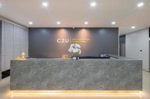 a lobby with a counter with flowers on it at C2U Hotel Uthai Thani in Ban Khok Mo