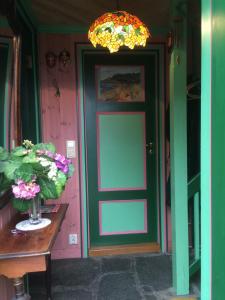 a vase of flowers sitting on a table in front of a door at Annehelenes B&B in Bergen