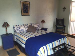 a bedroom with a bed with a blue blanket at Maria Del Alma House in Mexico City