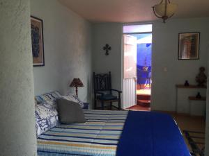 a bedroom with a bed with a blue comforter at Maria Del Alma House in Mexico City