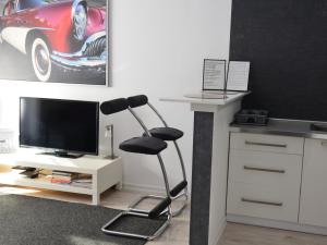 オルシュティンにあるApartamenty Szczęśliwe Snyのデスク、椅子、テレビが備わる客室です。