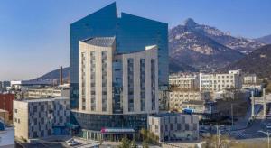 un gran edificio de cristal con una montaña en el fondo en Echarm Hotel Tai'an Taishan Tianwai Village Hongmen, en Tai'an