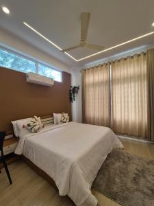 a bedroom with a large white bed and a window at Willow The Villas in Mananthavady